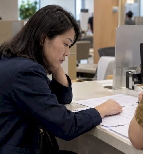 Buyer reviewing paperwork at an HDB counter