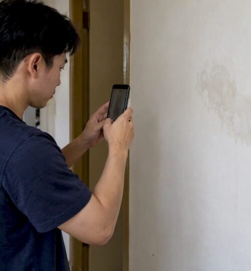 Tenant photographing a rental wall defect